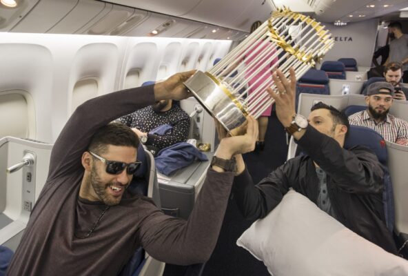 Somewhere between Los Angeles and Boston-- October 29, 2018-Stan Grossfeld/ Globe Staff—J.D. Martinez hands the World Series trophy off to Joe Kelly on the  Red Sox charter on the way back from winning the World Series in Los Angeles.